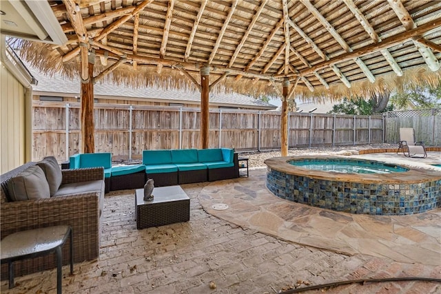 view of patio / terrace with a gazebo, an outdoor hot tub, outdoor lounge area, and a fenced backyard