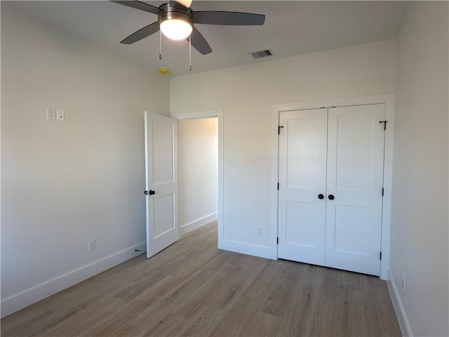 unfurnished bedroom featuring visible vents, a ceiling fan, wood finished floors, a closet, and baseboards