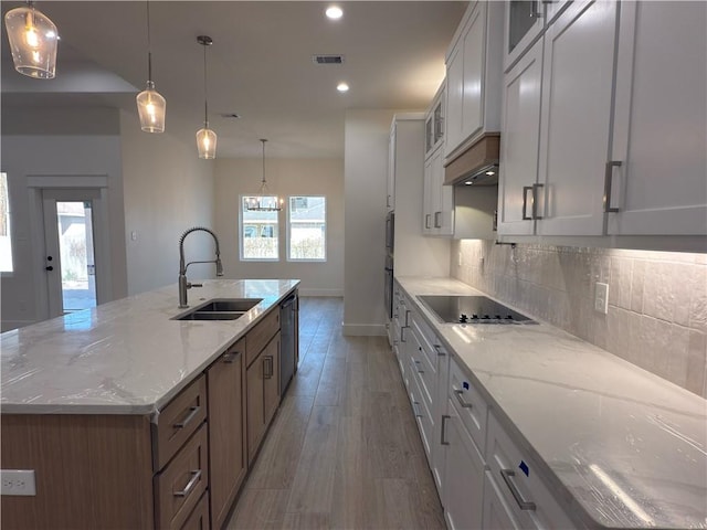 kitchen featuring tasteful backsplash, visible vents, black electric stovetop, dishwasher, and a sink