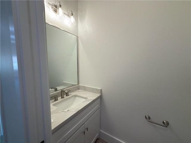 half bathroom featuring baseboards and vanity