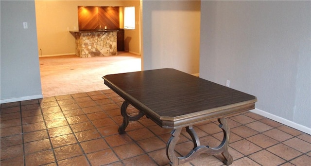 dining space with dark colored carpet and baseboards