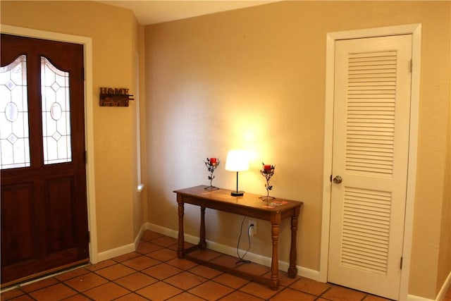 tiled foyer entrance featuring baseboards and a wealth of natural light