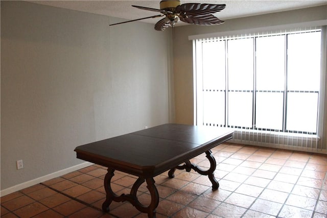 unfurnished dining area with baseboards, a ceiling fan, and a healthy amount of sunlight