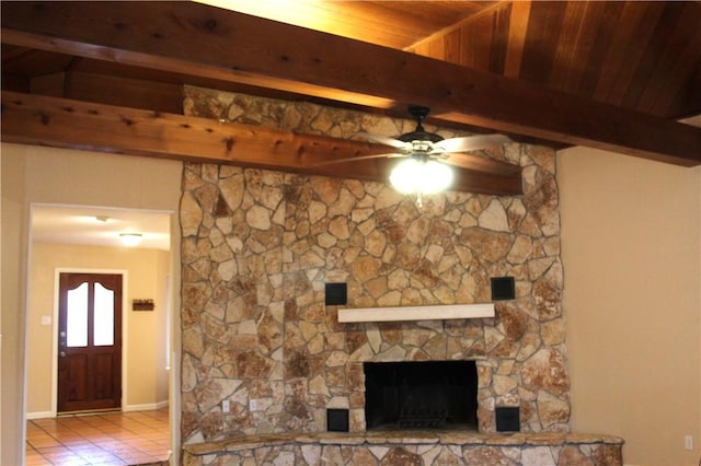 unfurnished living room featuring a fireplace, a ceiling fan, beam ceiling, and light tile patterned flooring