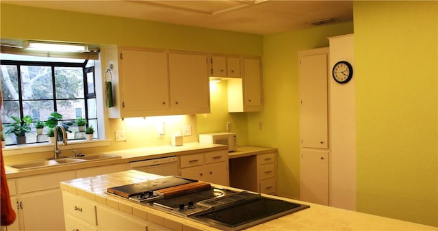 kitchen with tile countertops, white appliances, visible vents, and a sink