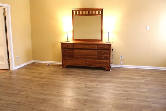 bedroom with baseboards and wood finished floors