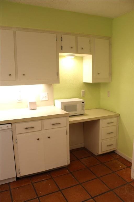 kitchen with white appliances, dark tile patterned floors, white cabinetry, and light countertops