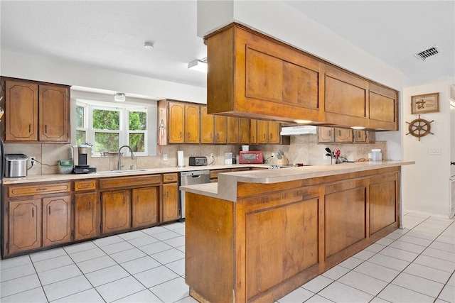 1689 Mooney Ln, Ingleside, TX 78362 - kitchen featuring stainless steel dishwasher, light tile patterned flooring, brown cabinets, light countertops, and backsplash