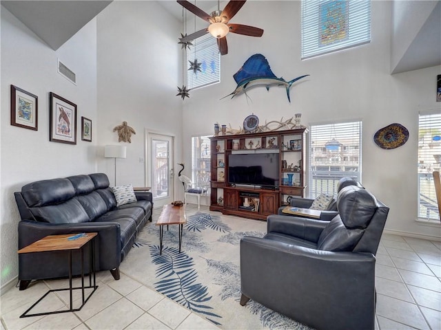 living area featuring a ceiling fan, visible vents, baseboards, and light tile patterned flooring