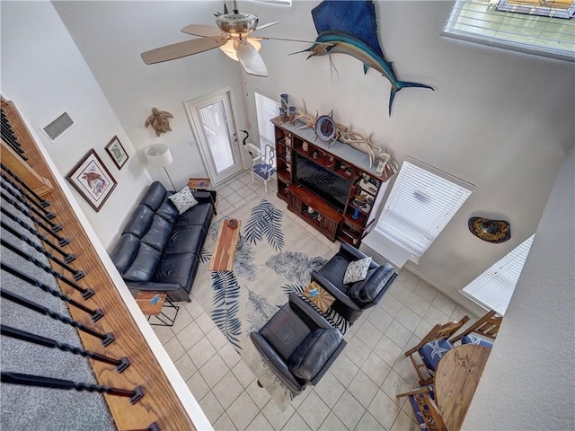 tiled living room featuring ceiling fan, plenty of natural light, and visible vents