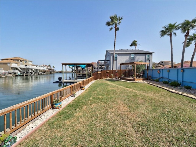 view of dock with a water view, a yard, and fence