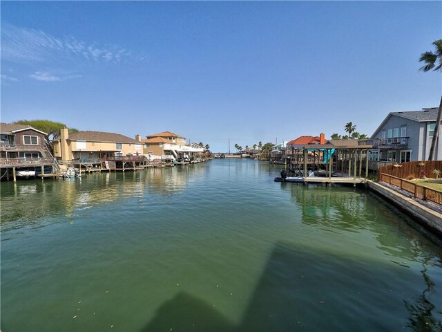 dock area with a residential view, a water view, and fence