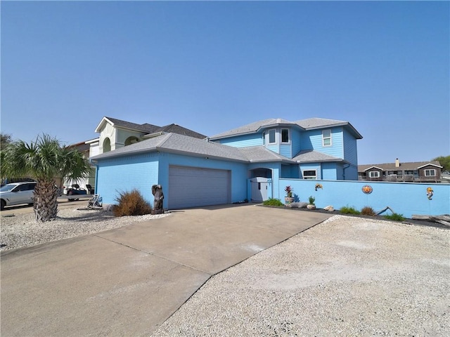 view of front of home with a garage, driveway, and fence