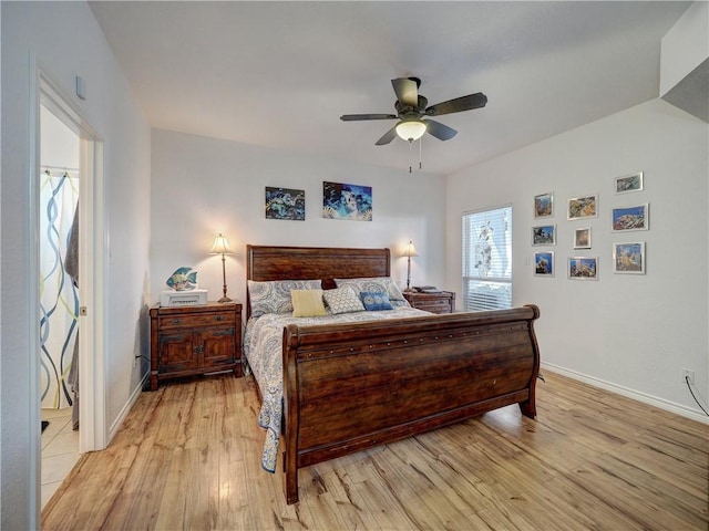 bedroom featuring ceiling fan, light wood-style flooring, and baseboards