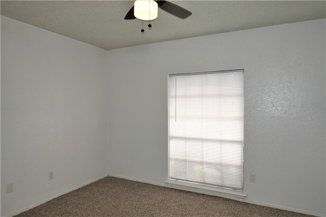 spare room with carpet flooring, a wealth of natural light, and ceiling fan