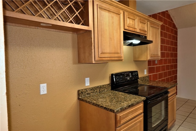 kitchen with light tile patterned flooring, dark stone countertops, black range with electric stovetop, and vaulted ceiling