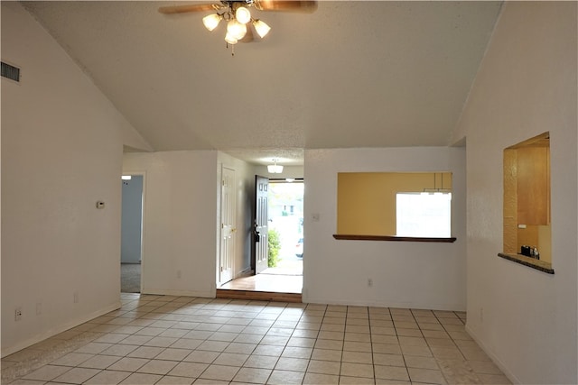 tiled empty room featuring a textured ceiling, ceiling fan, and lofted ceiling