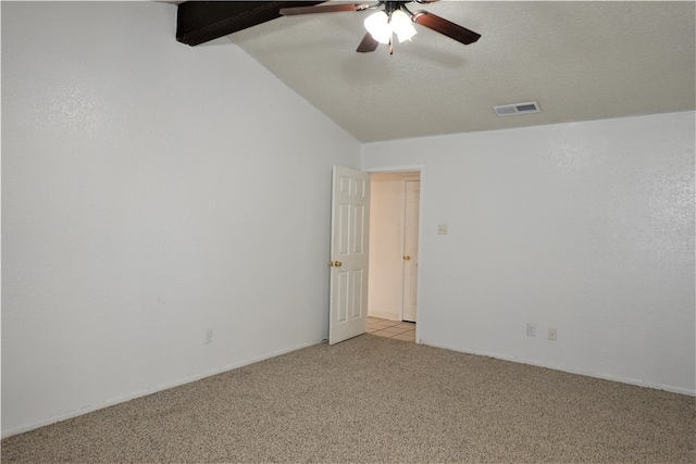 carpeted spare room with ceiling fan, lofted ceiling with beams, and a textured ceiling