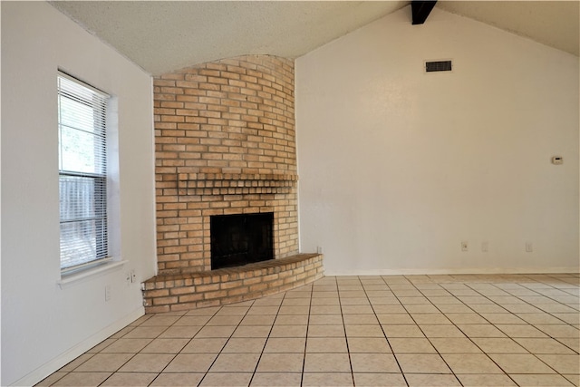 unfurnished living room featuring vaulted ceiling with beams, a fireplace, light tile patterned floors, and a healthy amount of sunlight