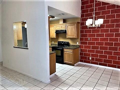 kitchen with black electric range oven, pendant lighting, light tile patterned floors, and a notable chandelier