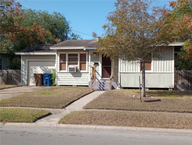 view of front of home featuring a garage, cooling unit, and a front yard