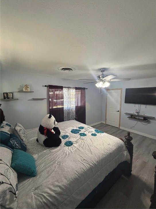 bedroom featuring dark hardwood / wood-style flooring and ceiling fan