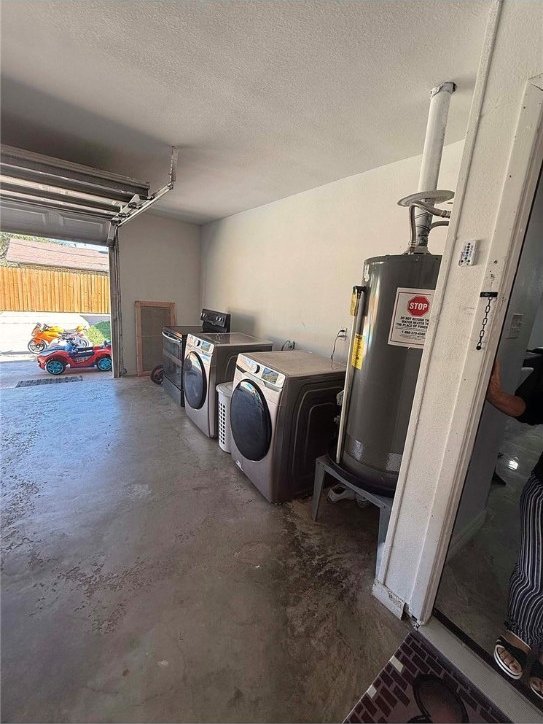 garage featuring water heater and washer and dryer