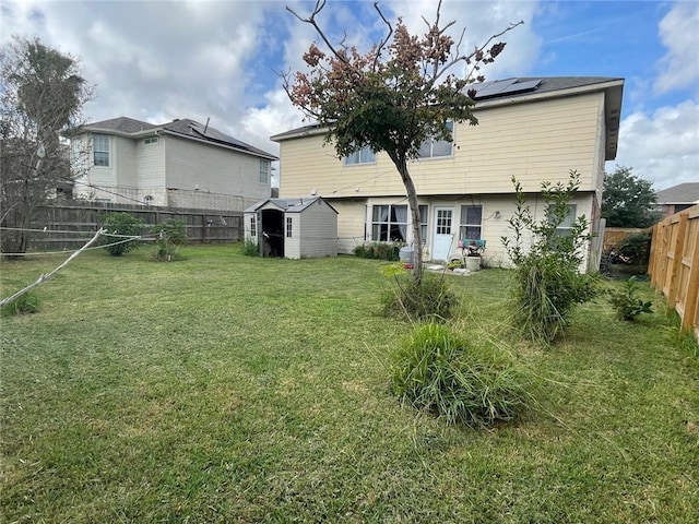 back of property with a storage unit and a lawn