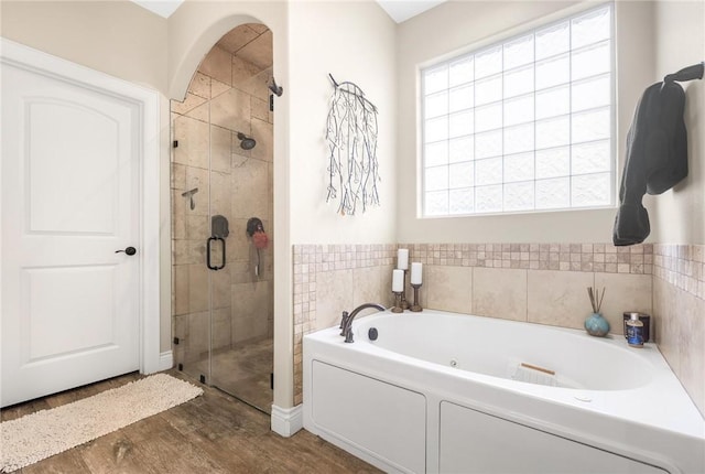 full bath with a garden tub, wood finished floors, and a stall shower