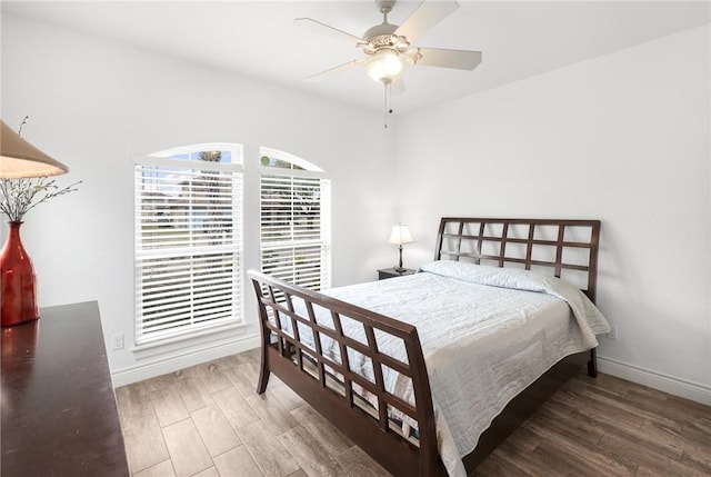 bedroom featuring a ceiling fan, baseboards, and wood finished floors