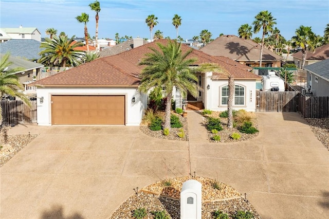 view of front of home featuring a garage, driveway, fence, and stucco siding