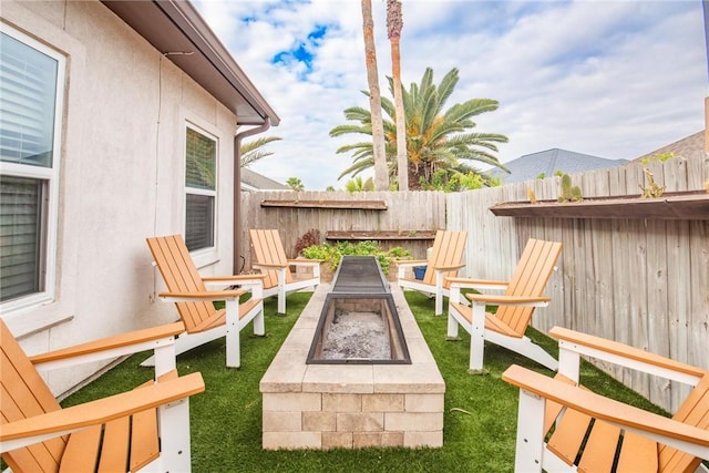 view of yard with an outdoor fire pit and fence