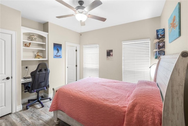 bedroom with a ceiling fan, baseboards, and wood finished floors