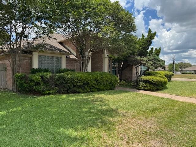 718 Broadway Blvd, Portland, TX 78374 - view of property hidden behind natural elements featuring brick siding, a front yard, and an attached garage