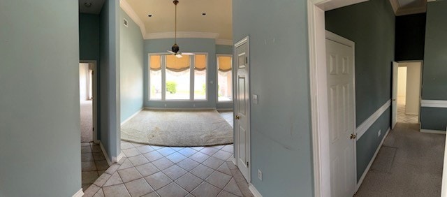 718 Broadway Blvd, Portland, TX 78374 - hall featuring light colored carpet, baseboards, light tile patterned floors, ornamental molding, and a towering ceiling