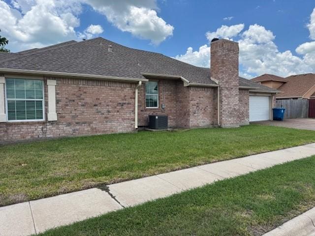 718 Broadway Blvd, Portland, TX 78374 - view of side of property with an attached garage, a shingled roof, a chimney, concrete driveway, and central AC