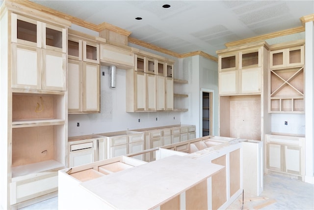 kitchen with crown molding, cream cabinetry, and a kitchen island