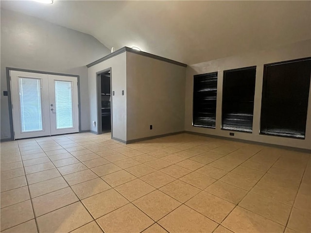 spare room featuring light tile patterned floors, french doors, lofted ceiling, and baseboards