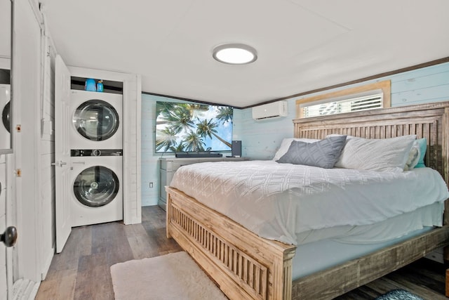 bedroom with multiple windows, stacked washer and clothes dryer, dark hardwood / wood-style floors, and a wall mounted air conditioner