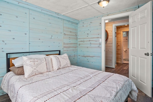 bedroom with dark hardwood / wood-style flooring and wood walls