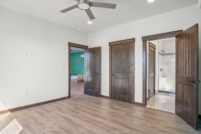 unfurnished bedroom featuring light hardwood / wood-style floors, ceiling fan, and connected bathroom