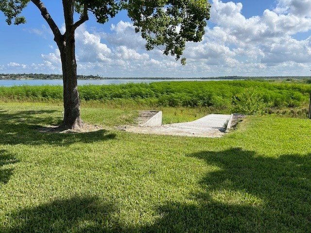 view of community featuring a water view and a yard