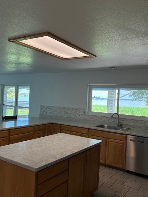 kitchen with tasteful backsplash, dishwasher, sink, and a healthy amount of sunlight