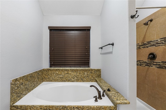 bathroom featuring independent shower and bath and a textured ceiling