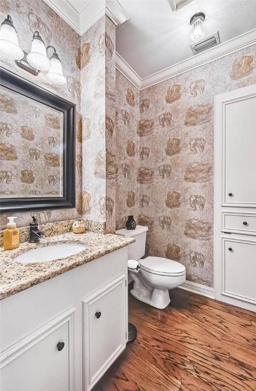 5918 Woodmere Dr, Corpus Christi, TX 78414 - half bathroom with wallpapered walls, crown molding, vanity, wood finished floors, and toilet