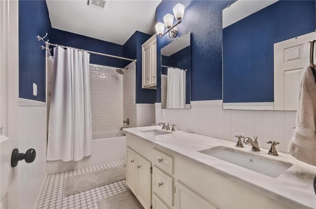 5918 Woodmere Dr, Corpus Christi, TX 78414 - full bath with a wainscoted wall, shower / tub combo with curtain, and double vanity