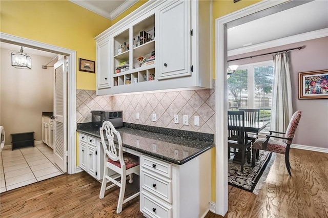 5918 Woodmere Dr, Corpus Christi, TX 78414 - kitchen with ornamental molding, white cabinetry, tasteful backsplash, wood finished floors, and dark stone counters