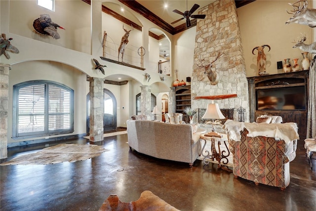 living room featuring decorative columns, ceiling fan, beam ceiling, and a high ceiling