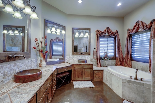 bathroom featuring tiled bath, vanity, and concrete floors