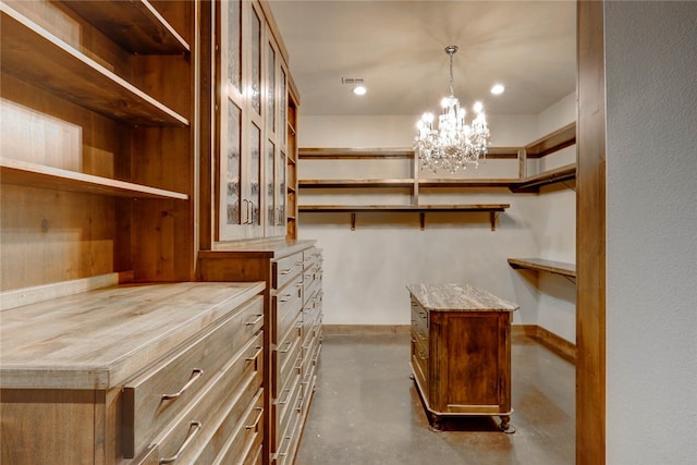 spacious closet featuring a chandelier